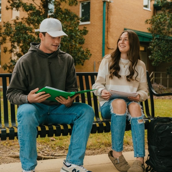 Two students studying on a bench at the Dublin campus